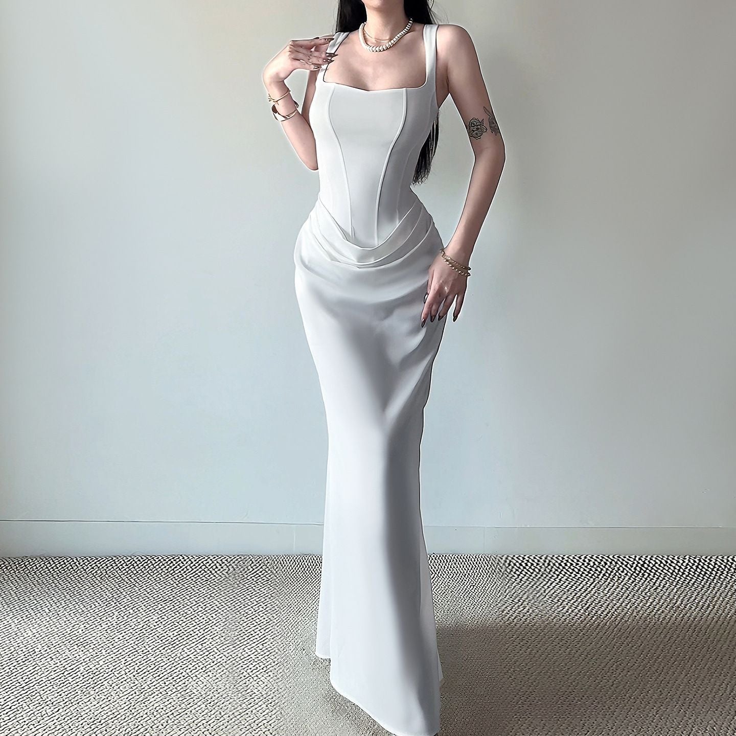 Vestido largo ajustado, sin mangas y con espalda descubierta, con bajo en forma de cola de sirena.